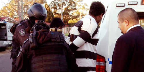 Police handcuff one of the four men and a youth arrested yesterday in a series of dramatic raids across Sydney following the brutal murder of Kesley Burgess, 25, during a home invasion at Lurnea on July 1. Police handcuff one of the four men and a youth arrested yesterday in a series of dramatic raids across Sydney following the brutal murder of Kesley Burgess, 25, during a home invasion at Lurnea on July 1.